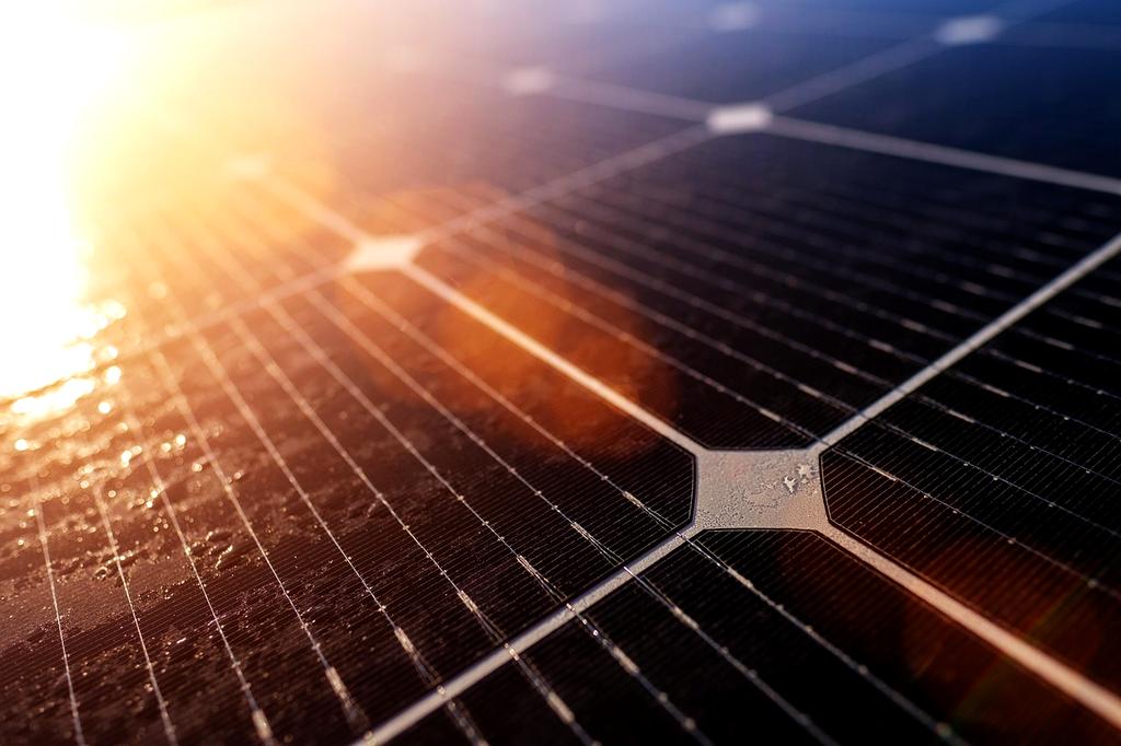 Solar panels reflecting sunlight in a green countryside