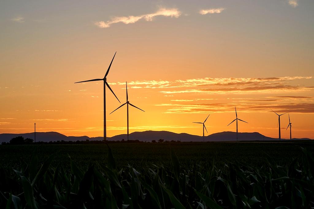 Innovator standing next to a massive wind turbine